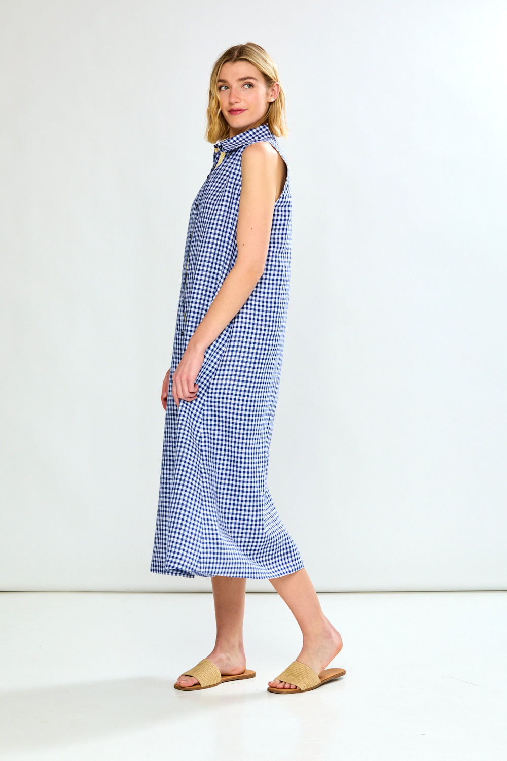 Woman wearing a blue and white checkered dress on a white background