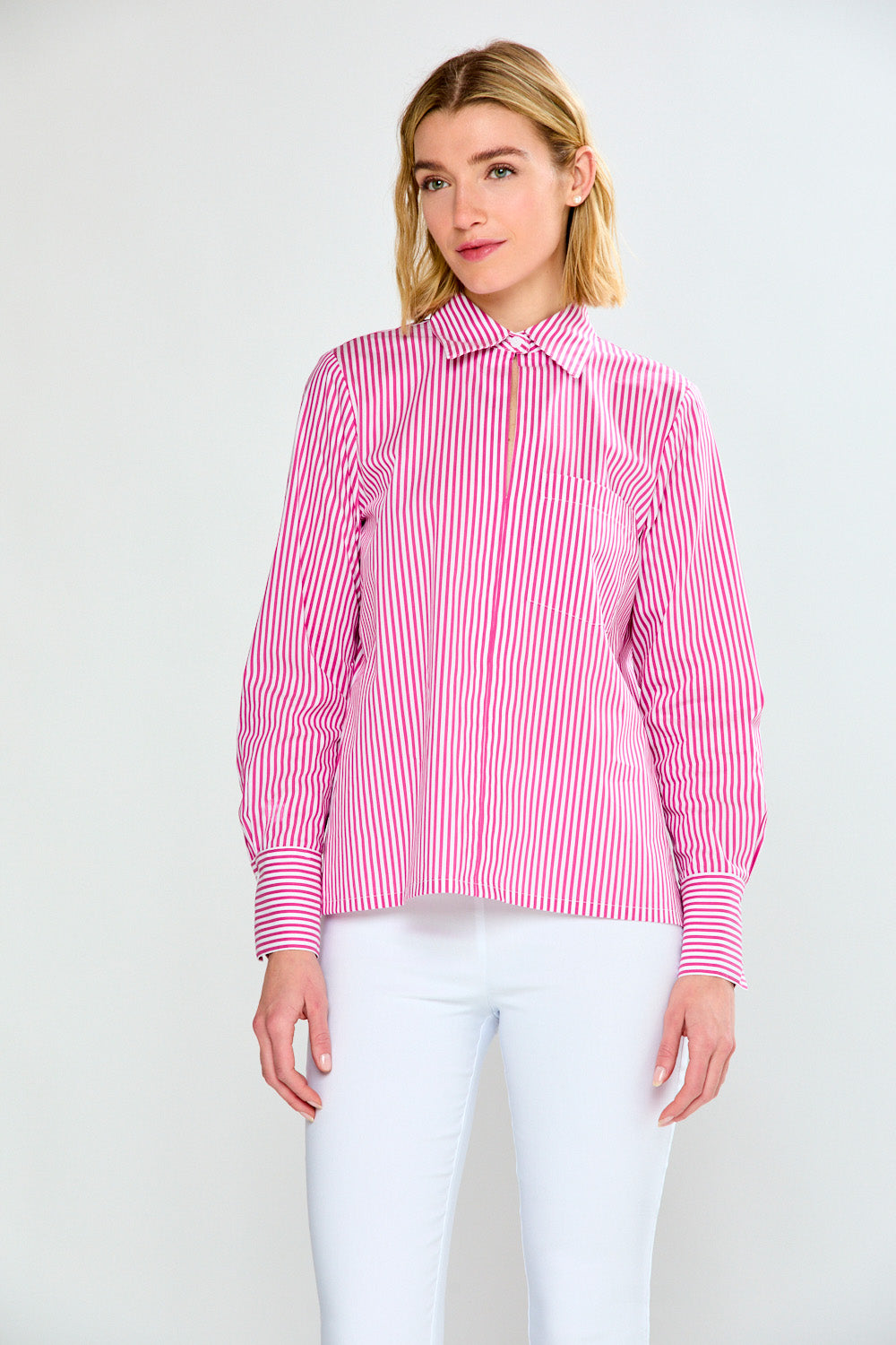 Woman wearing a pink and white striped shirt against a plain background