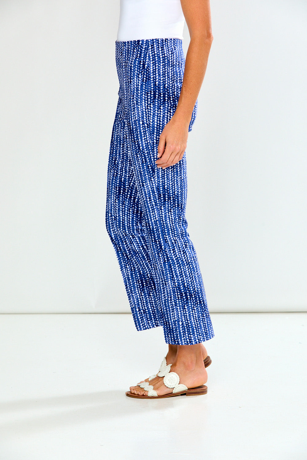 Woman wearing blue and white patterned pants on a white background