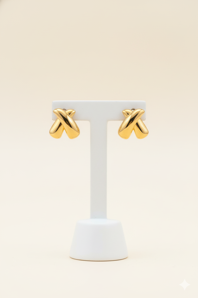 Gold crisscross earrings on an earring stand