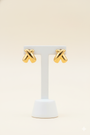 Gold crisscross earrings on an earring stand