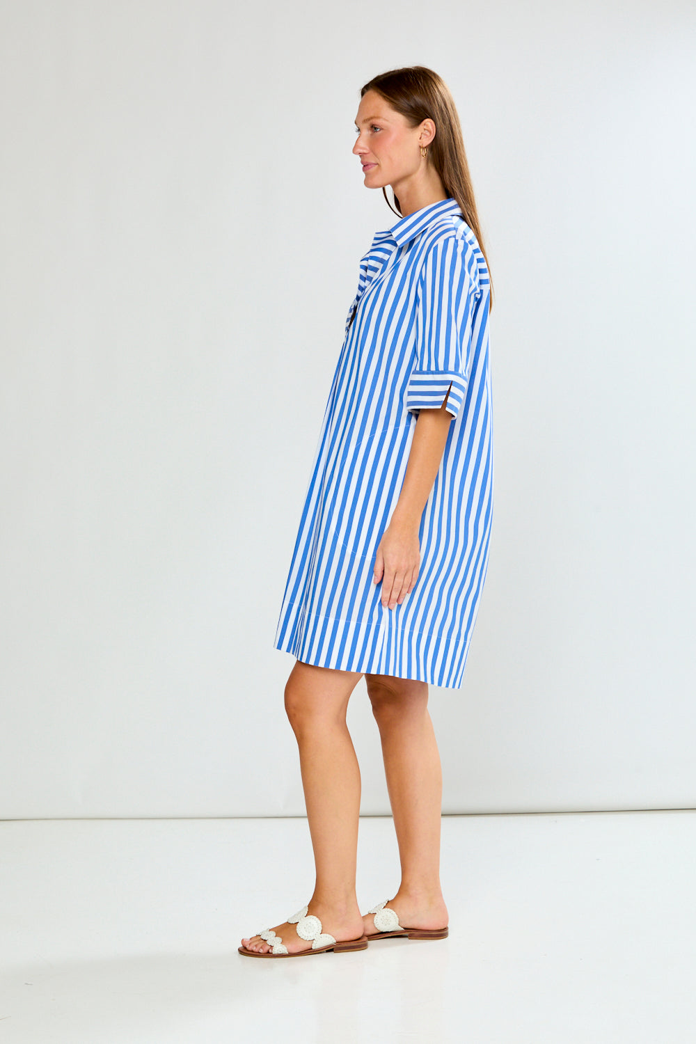 Woman wearing a blue and white striped dress on a white background