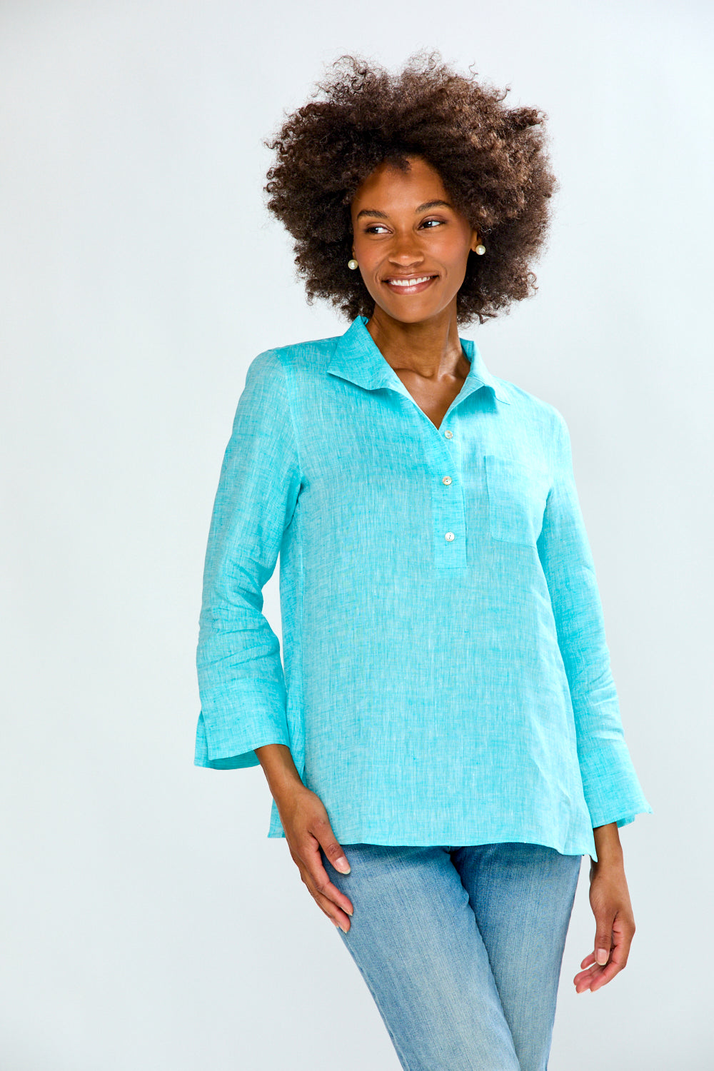 Woman wearing a light blue shirt and jeans on a white background