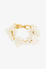 Gold bracelet with pearl-like beads on a white background