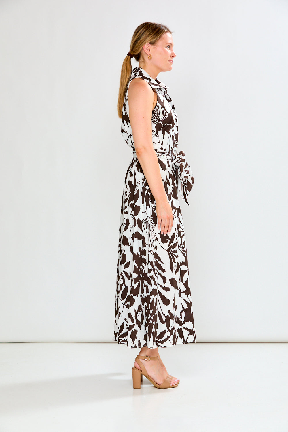 Woman wearing a sleeveless floral dress on a white background