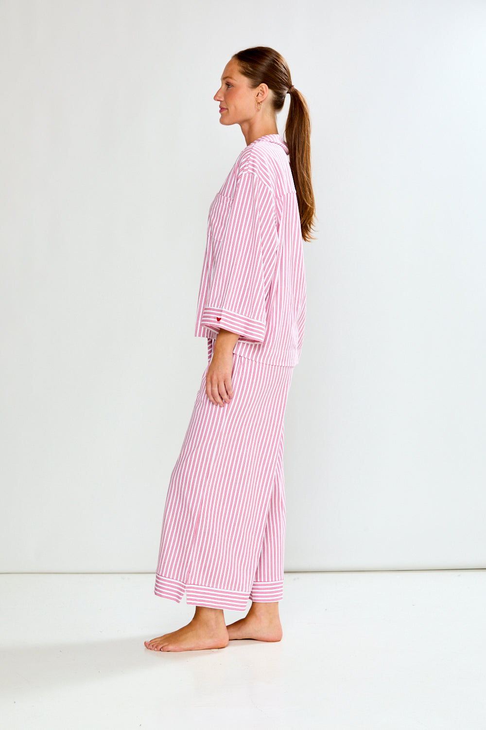 Woman wearing a red and white striped pajama set on a white background