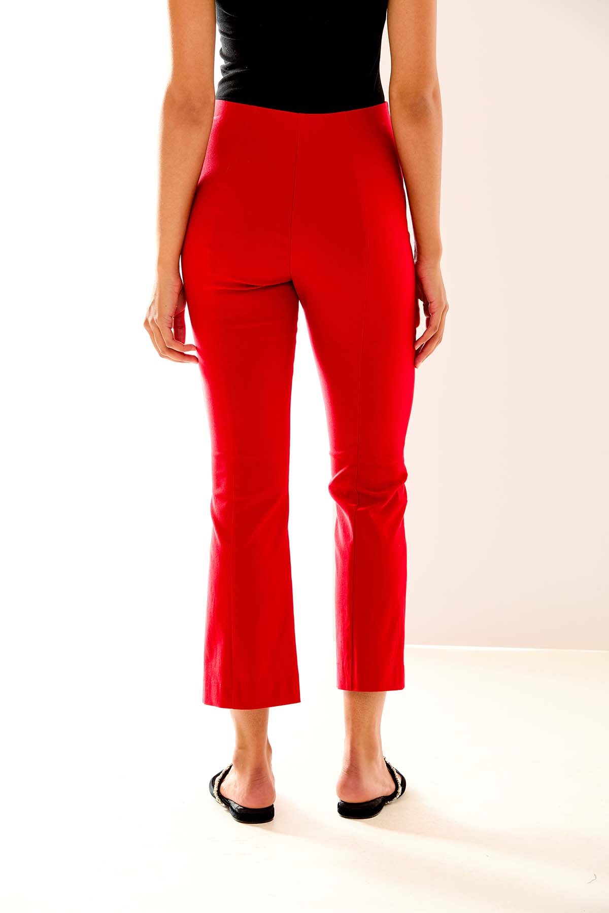 Person wearing red pants and a black top on a white background