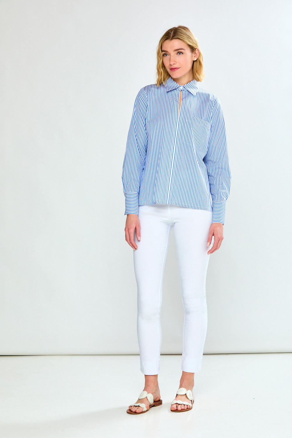 Woman wearing a blue and white striped shirt on a plain background