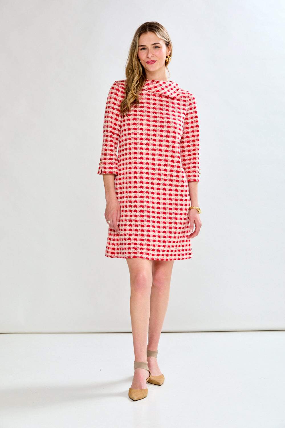 Woman wearing a red and white checkered dress on a white background