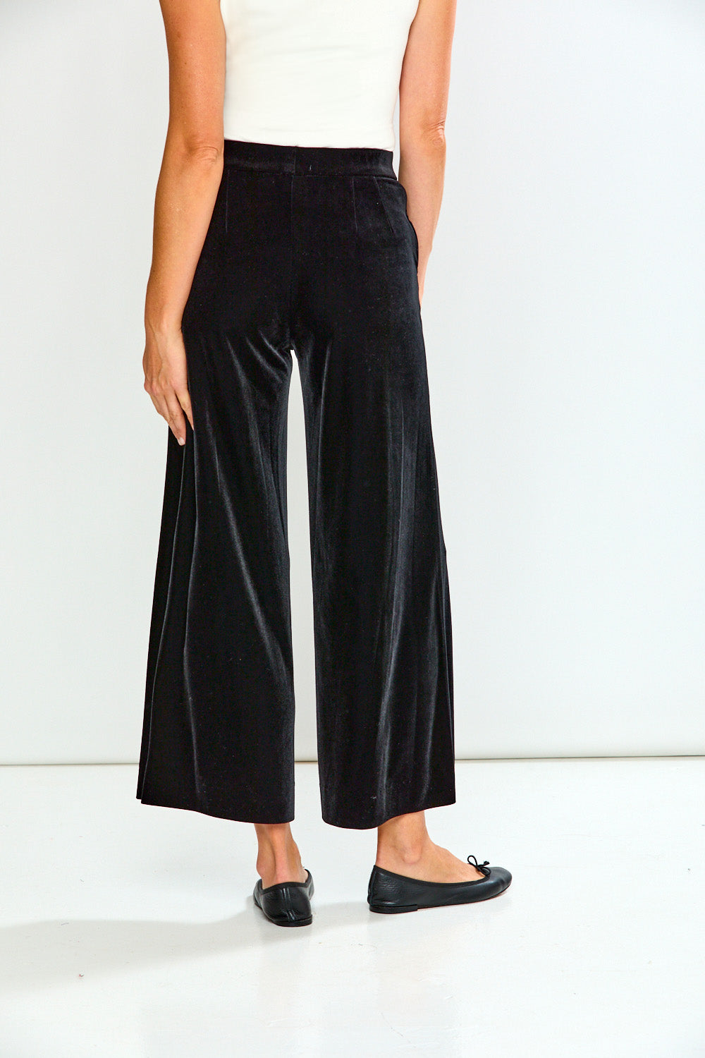 Person wearing black wide-leg pants on a white background