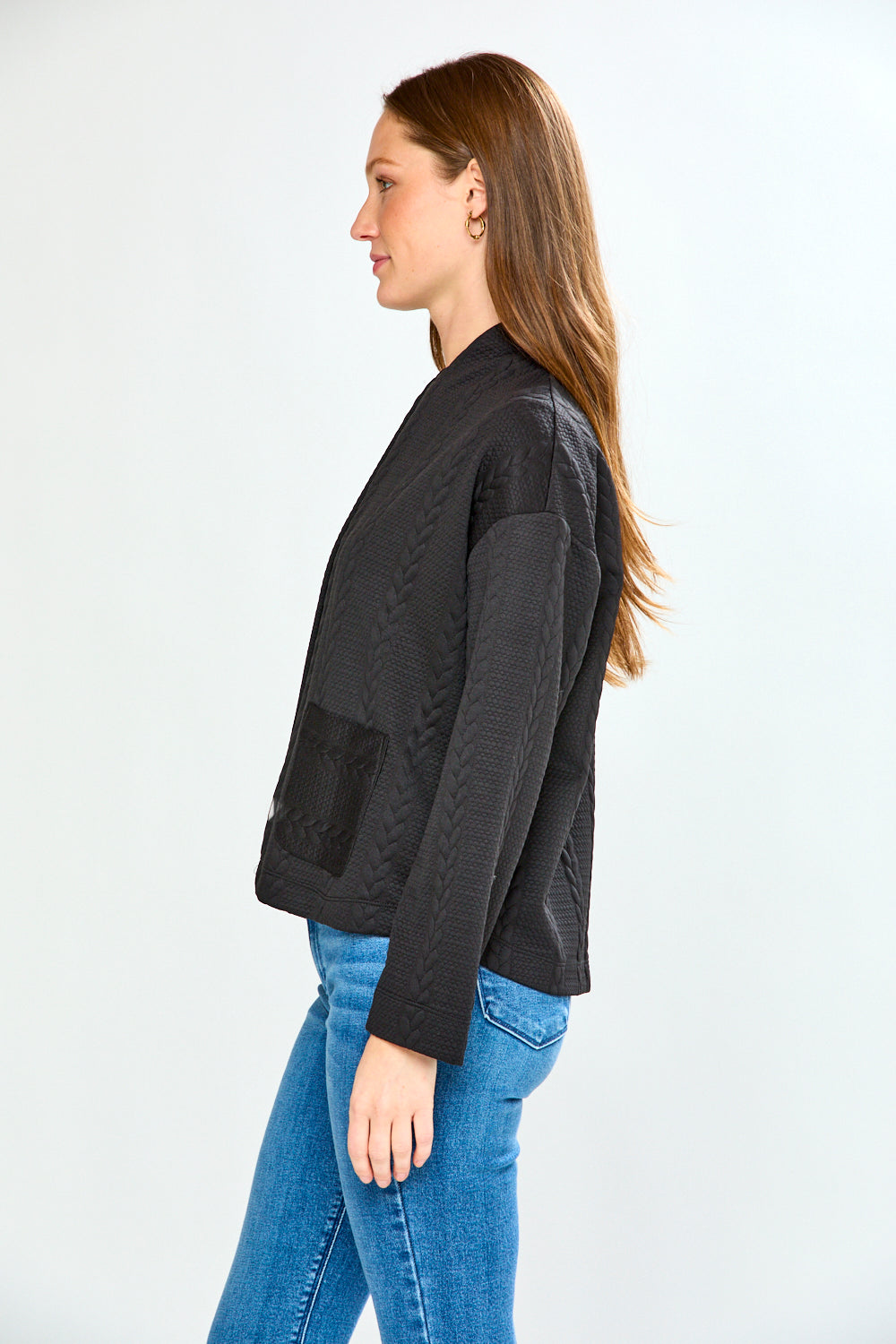 Woman wearing a black jacket and blue jeans on a white background