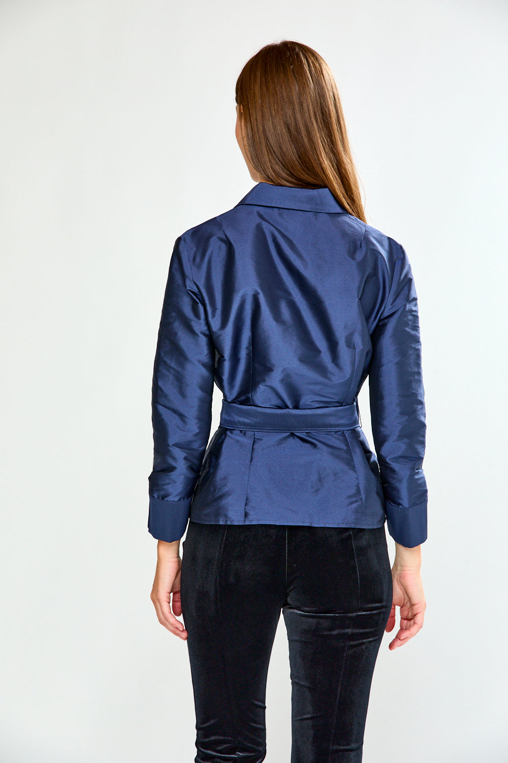 Woman wearing a blue blouse with a bow detail on a white background