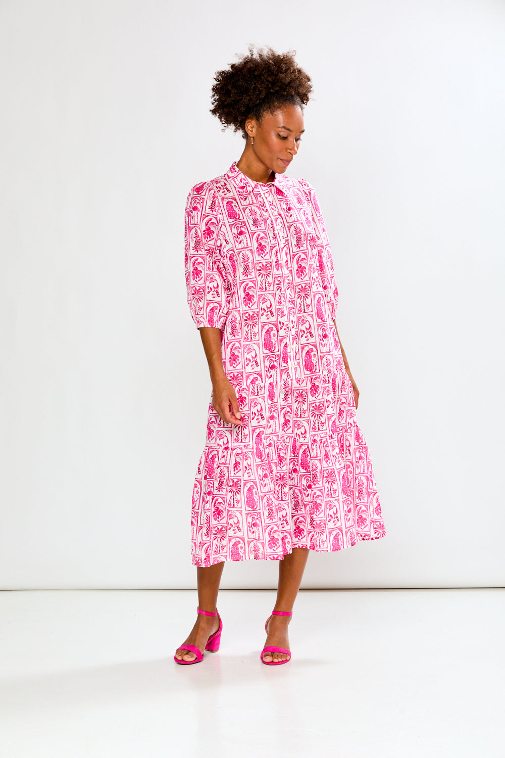 Woman wearing a pink and white patterned dress on a white background