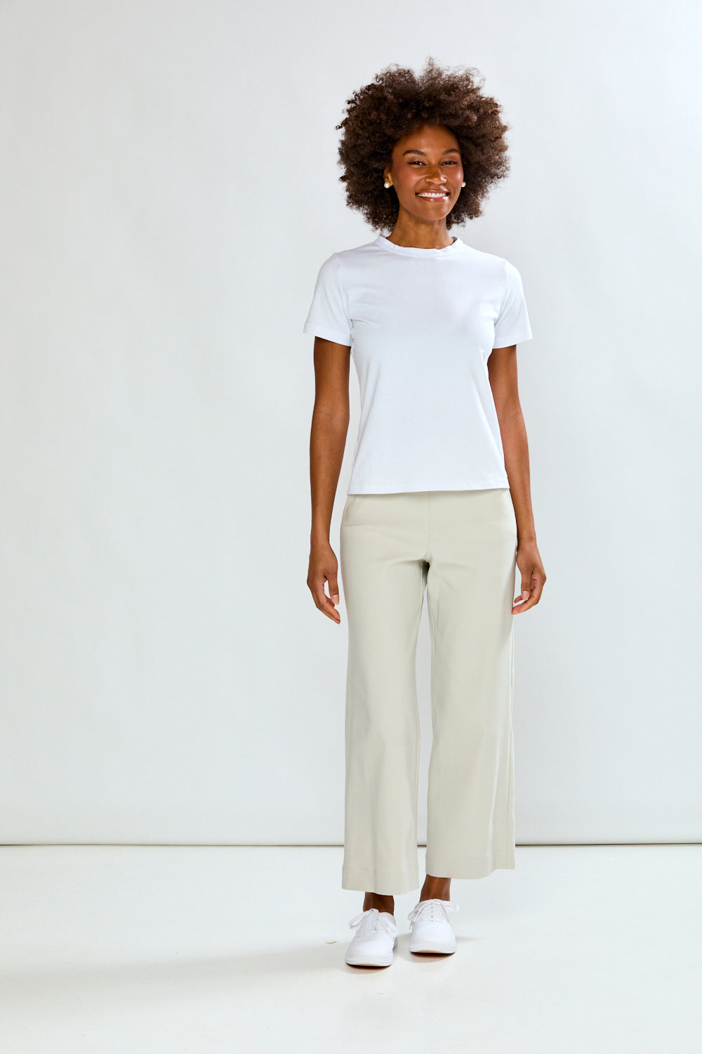 Person wearing a white t-shirt and beige pants on a white background