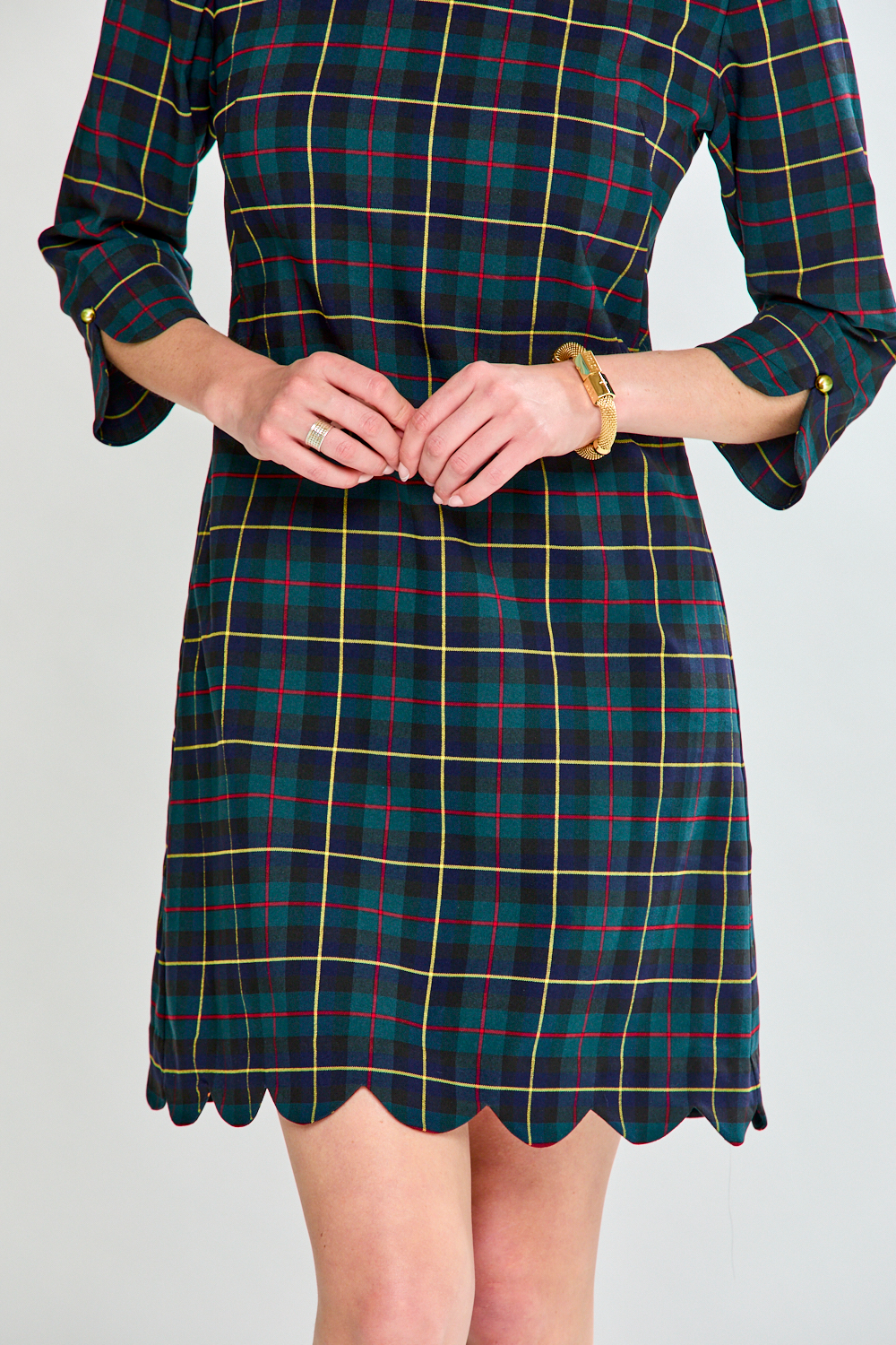 Plaid dress with scalloped hem on a plain background