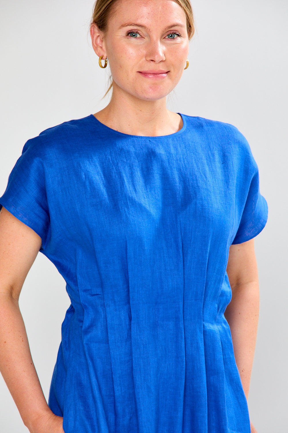 Woman wearing a blue dress against a plain background
