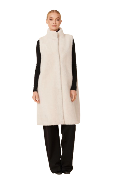 Woman wearing a long cream vest over a black outfit on a white background