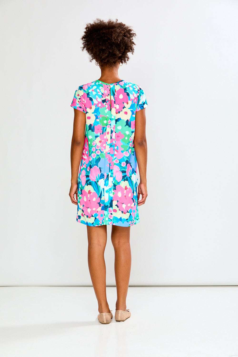 Woman wearing a colorful floral dress on a white background