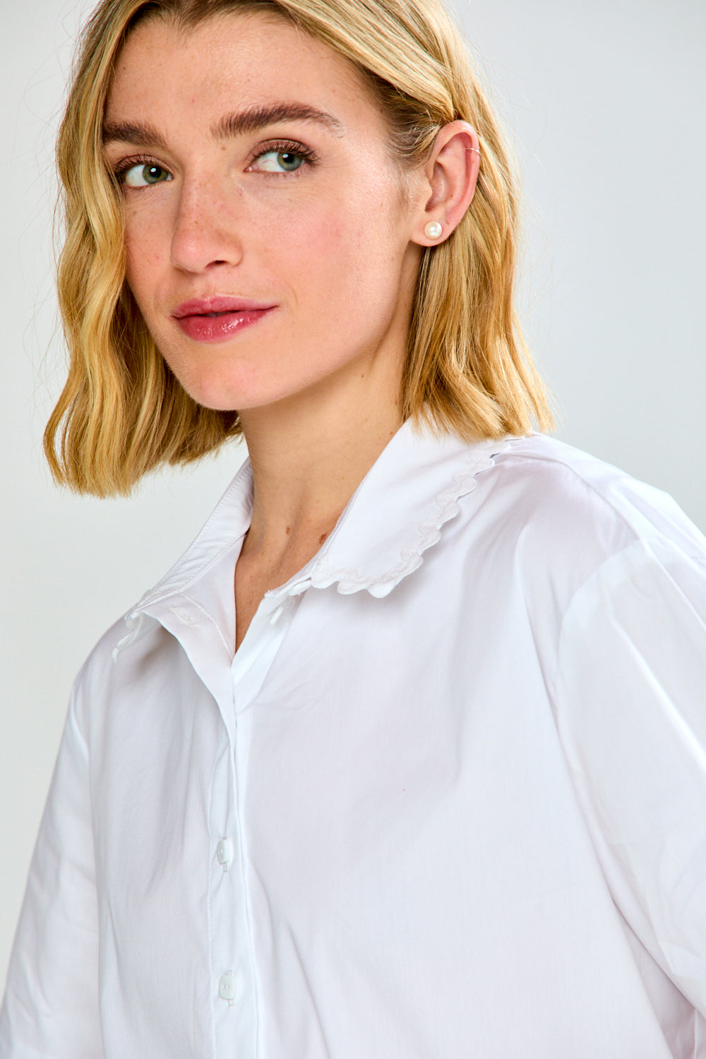 Woman wearing a white shirt against a plain background