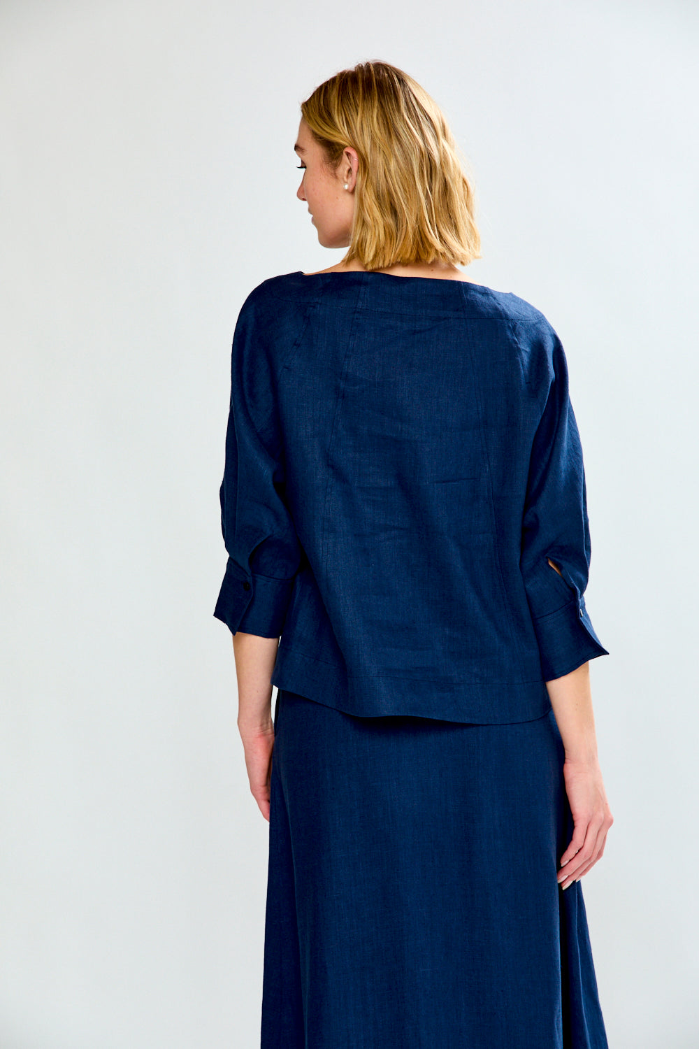Woman wearing a navy blue outfit against a white background