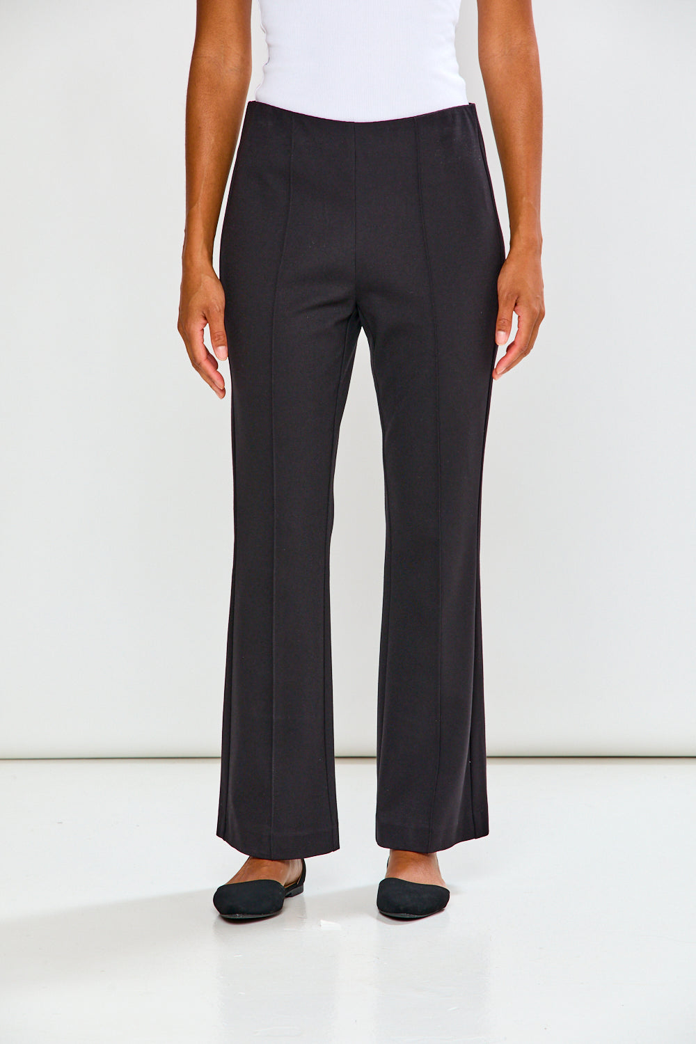 Person wearing black pants on a white background