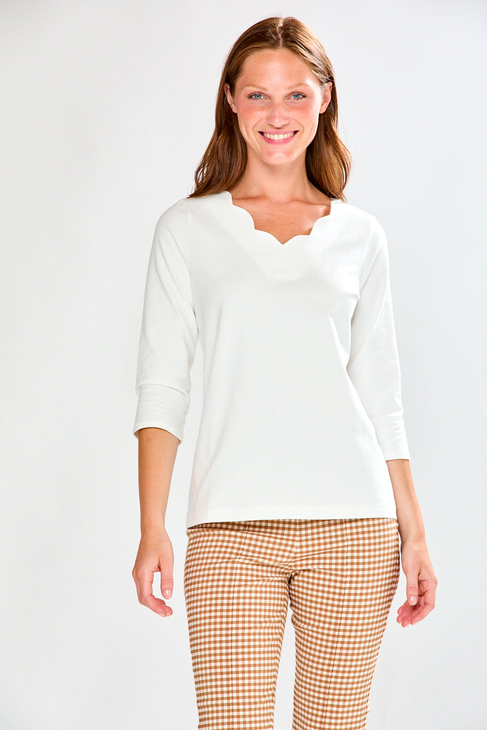 Woman wearing a white top and checkered pants on a white background