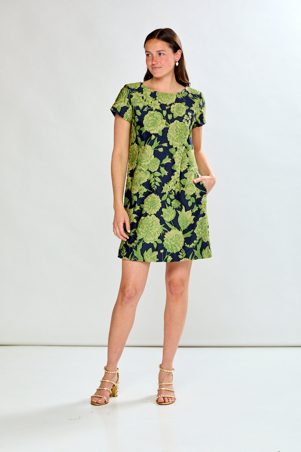 Woman wearing a green floral dress on a white background