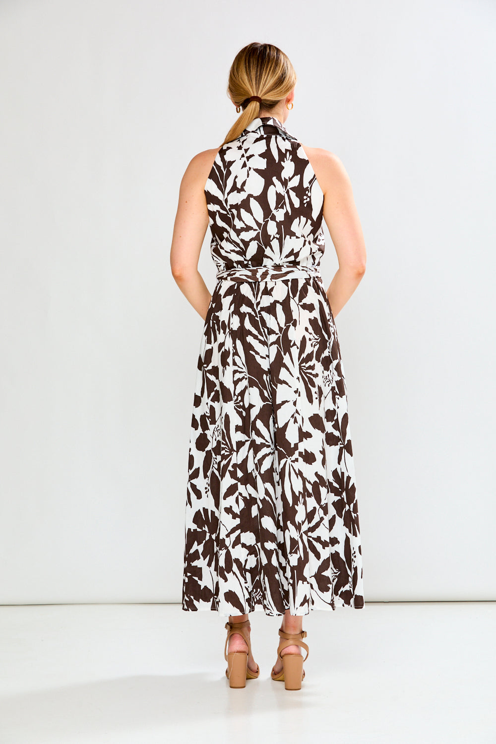 Woman wearing a sleeveless floral dress on a white background