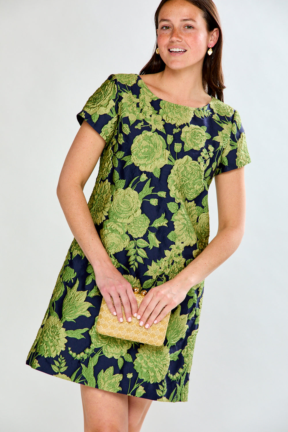 Woman wearing a green floral dress on a white background