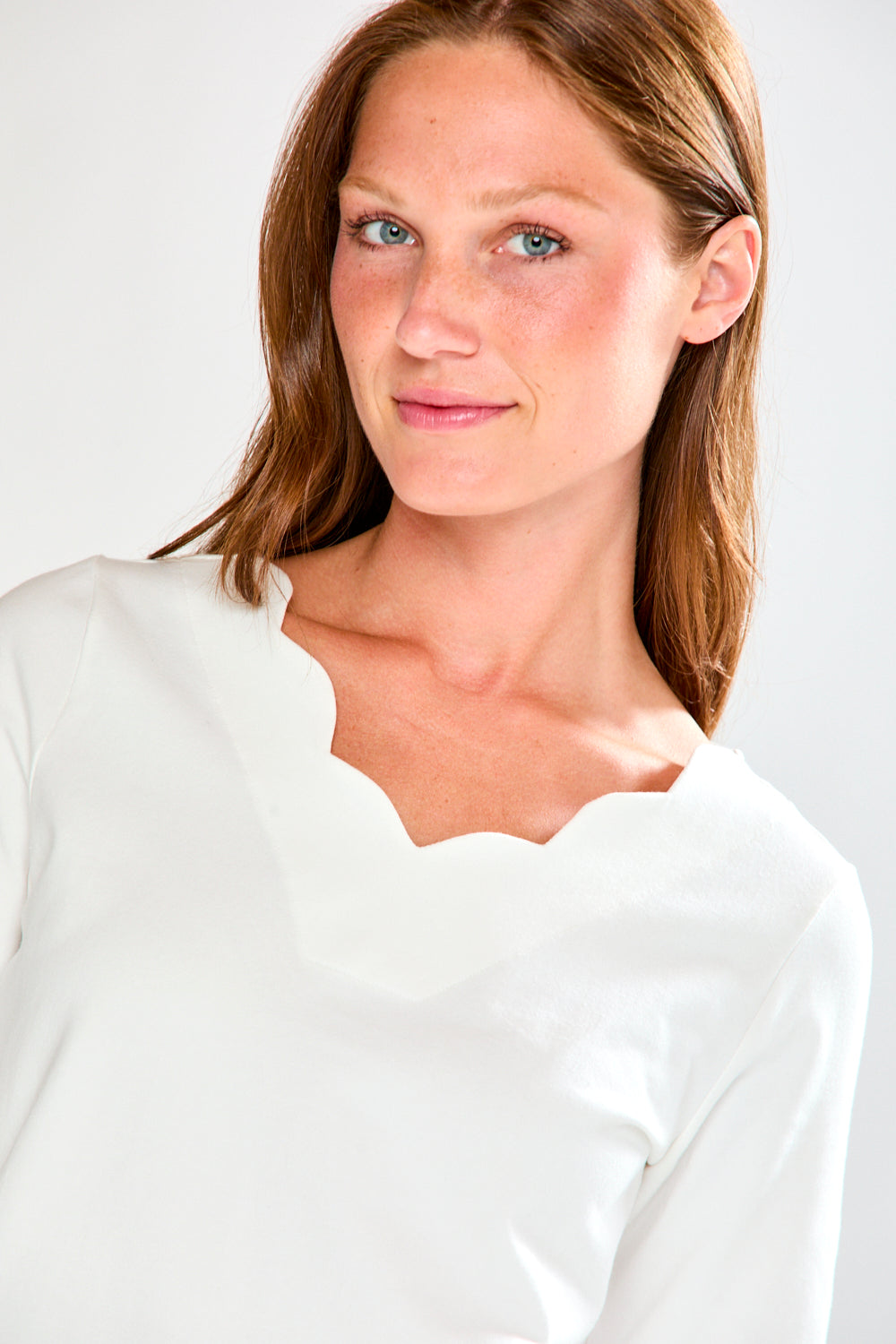 Woman wearing a white blouse against a plain background
