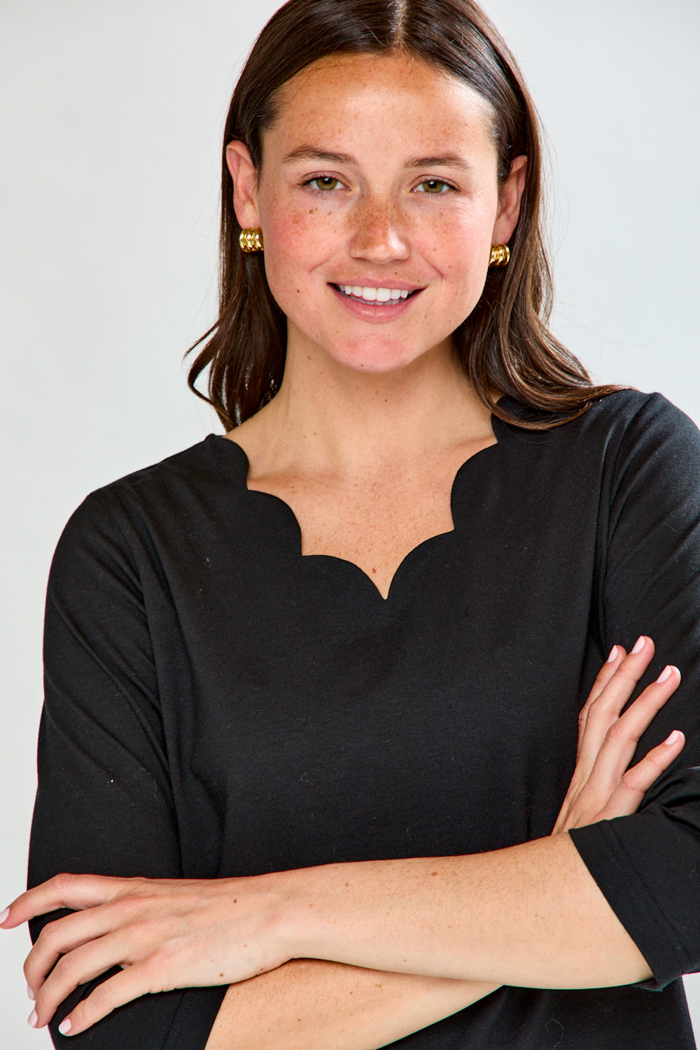 Woman wearing a black top with a plain background