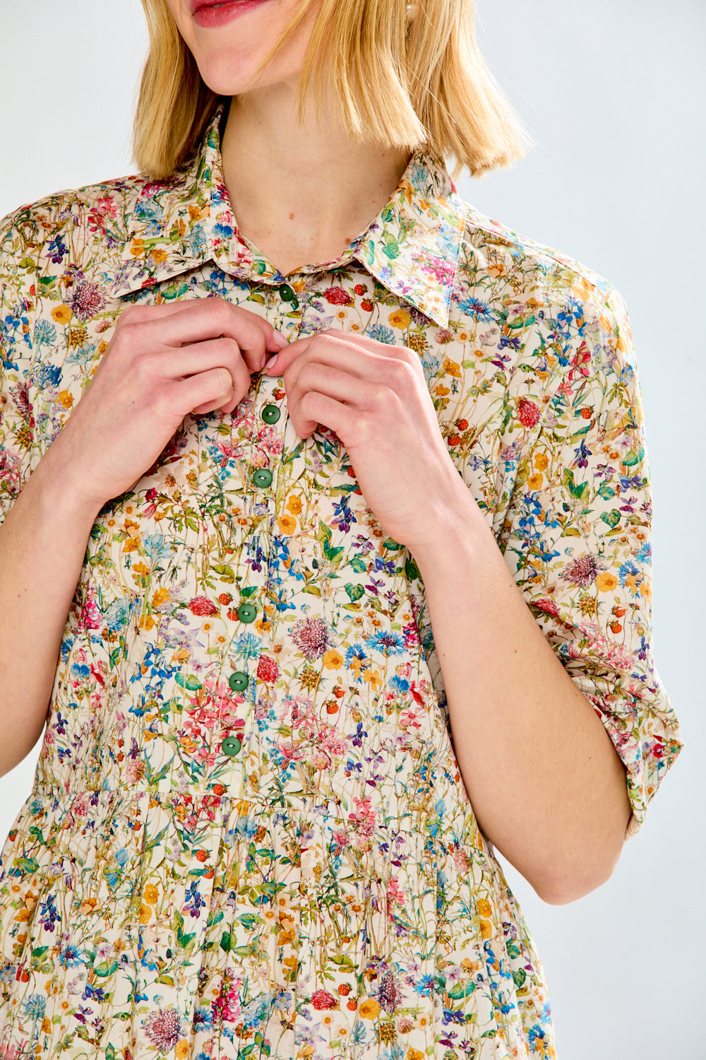 Person wearing a floral dress with a plain background