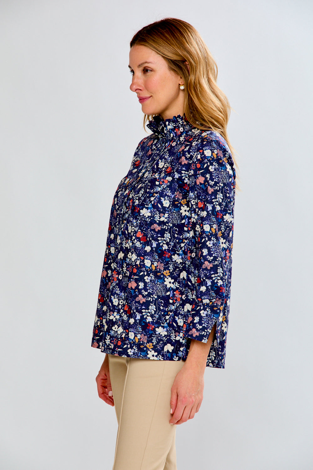 Woman wearing a floral patterned blouse against a plain background