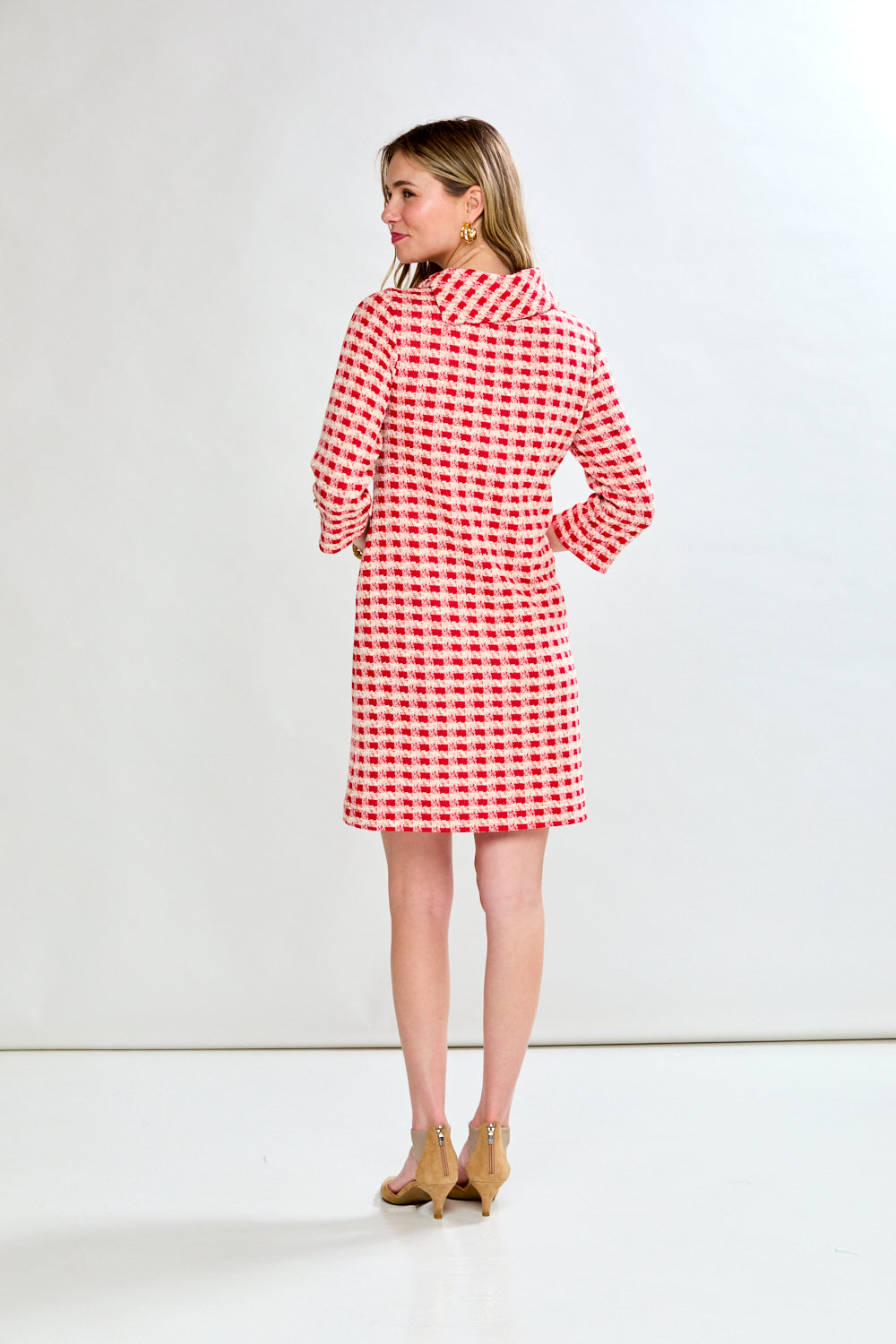 Woman wearing a red and white checkered dress on a white background