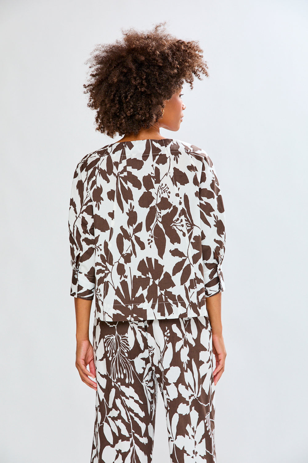 Woman wearing a patterned top on a white background