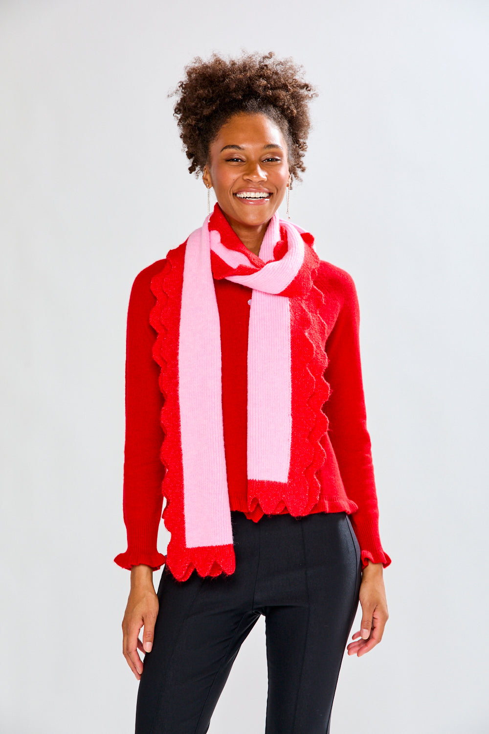 Woman wearing a red sweater and pink scarf on a white background