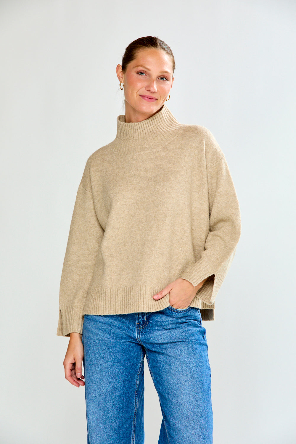 Woman in oat sweater with jeans