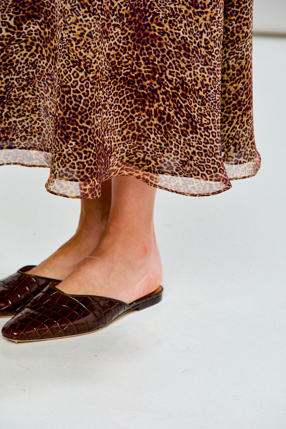 Person wearing a patterned skirt with a plain background