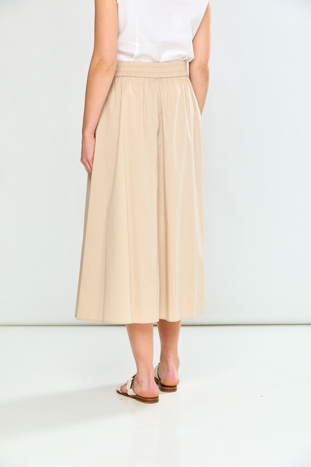 Person wearing a beige skirt on a white background