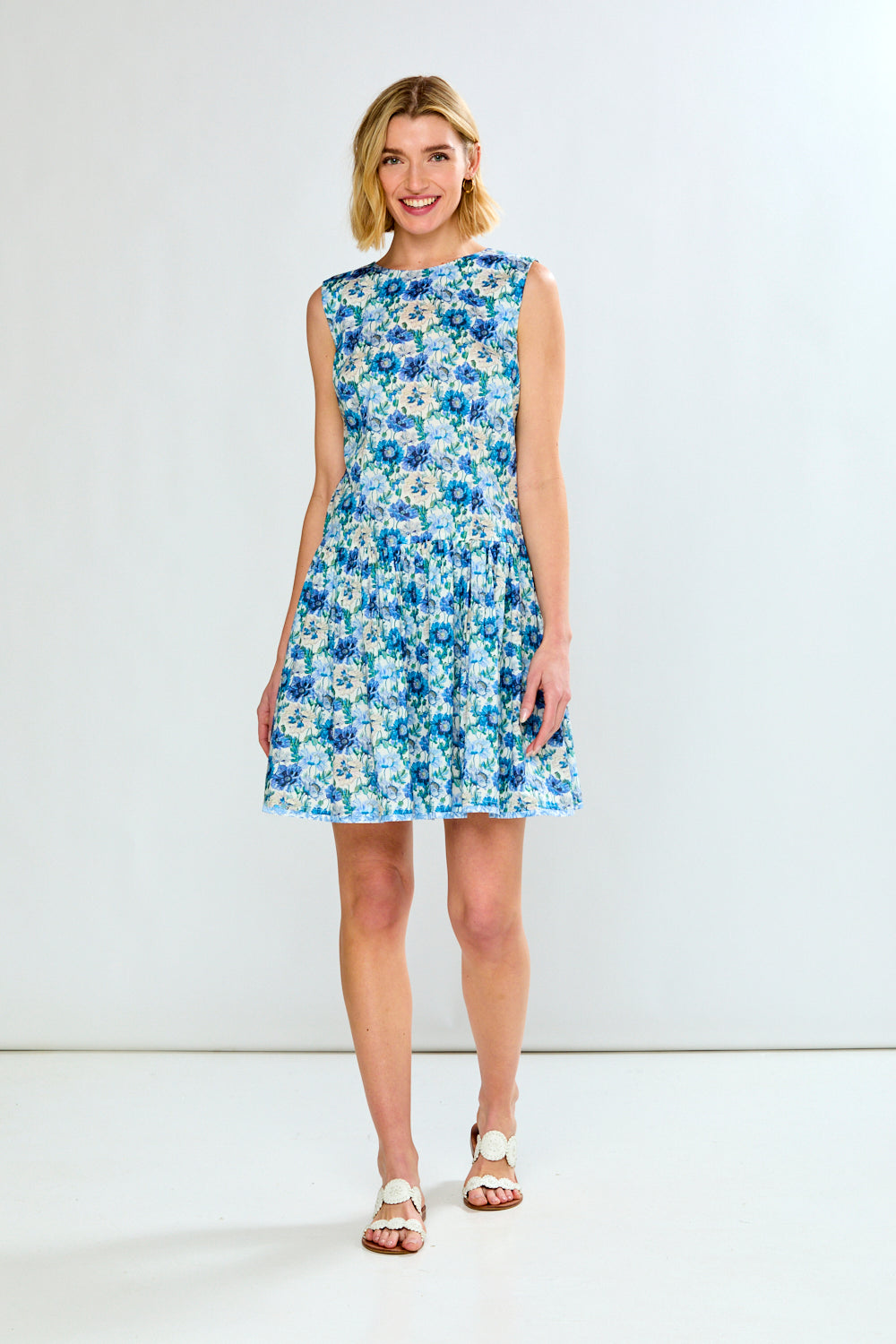 Woman wearing a blue floral dress against a white background