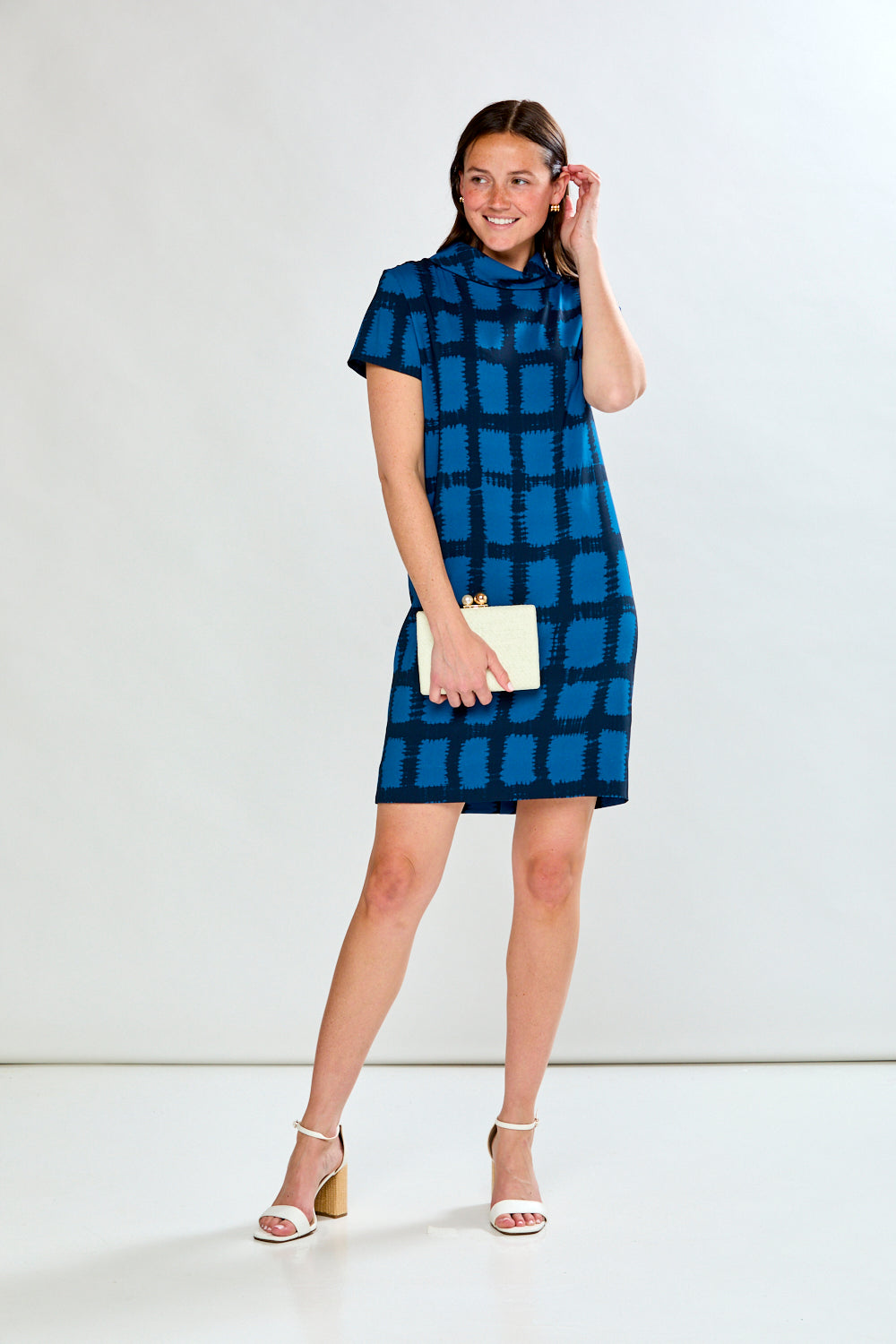 Woman wearing a blue checkered dress against a white background