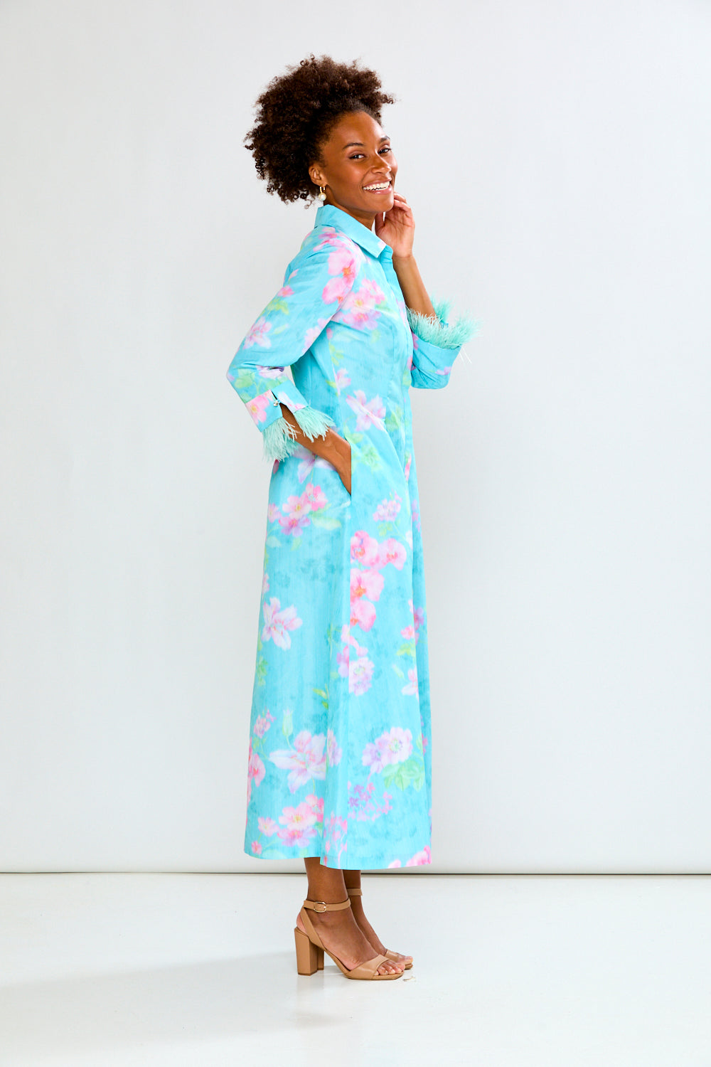 Woman wearing a light blue floral dress against a white background
