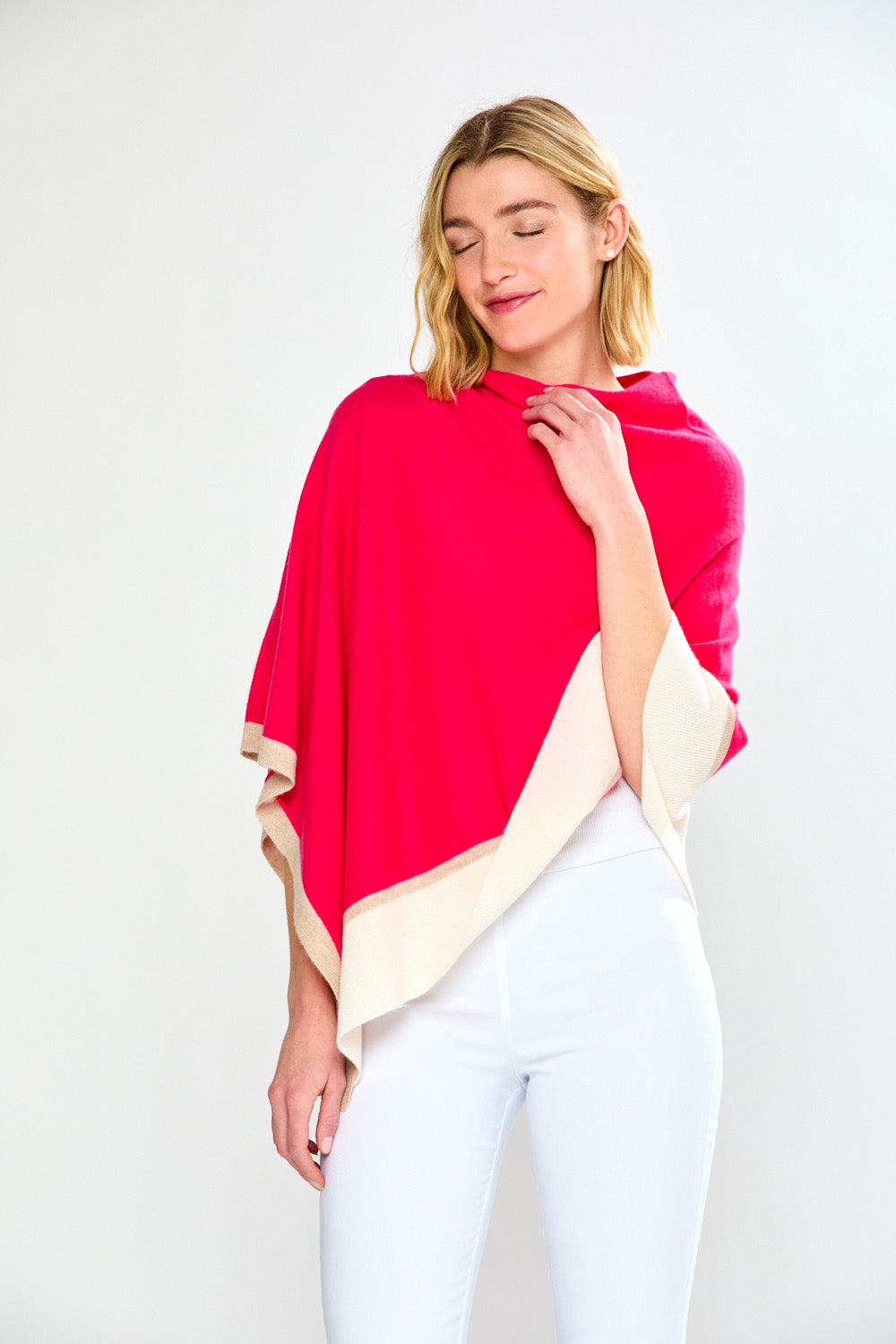 Woman wearing a red and beige poncho against a white background