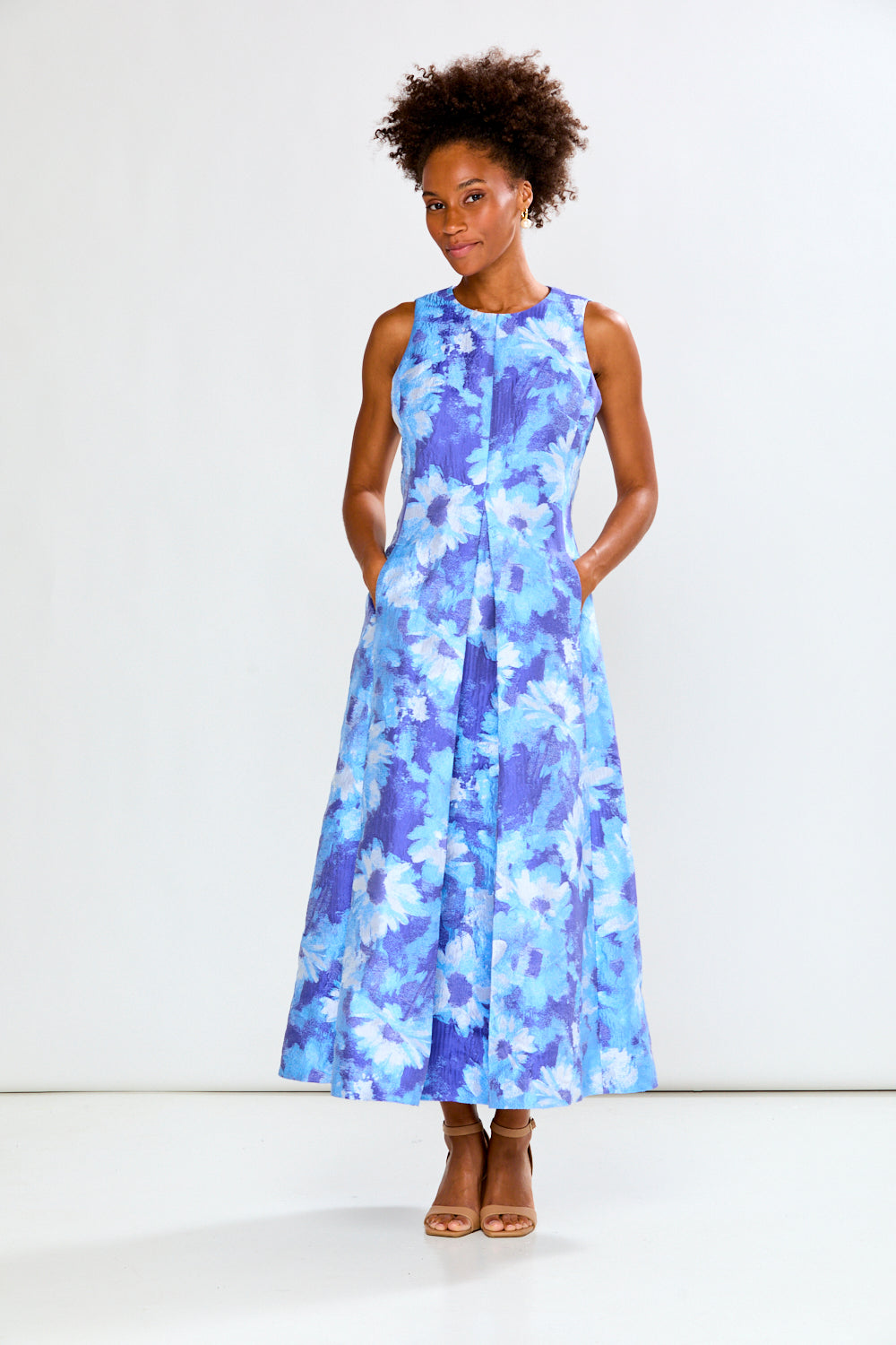 Woman wearing a blue floral dress against a white background