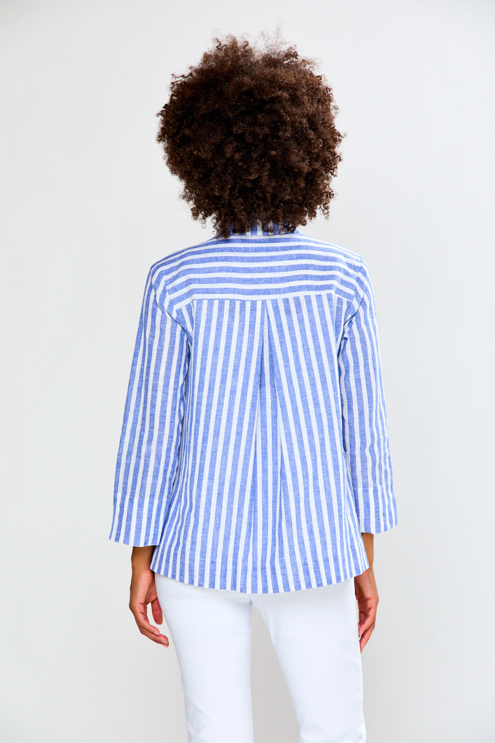 Woman wearing a blue and white striped shirt against a white background
