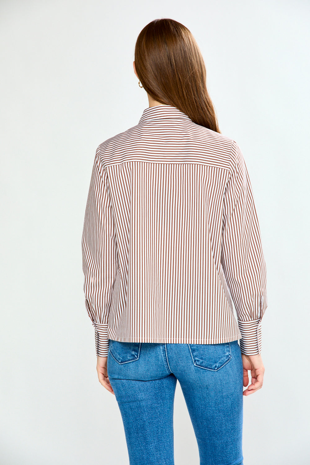 Woman wearing a striped shirt and jeans on a white background
