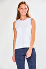 Woman wearing a white sleeveless top and blue jeans on a white background
