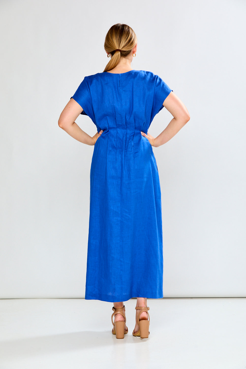 Woman wearing a blue dress against a white background