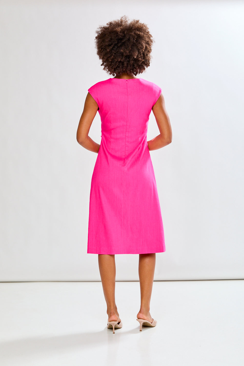 Woman wearing a fuchsia dress on a white background