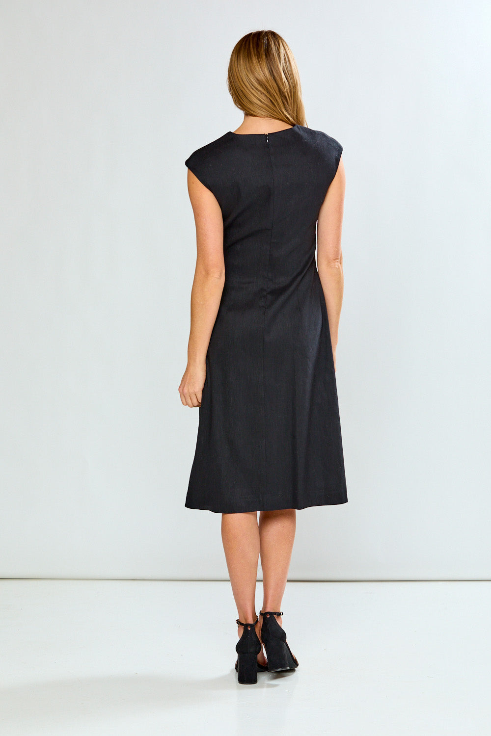 Woman wearing a black dress against a white background